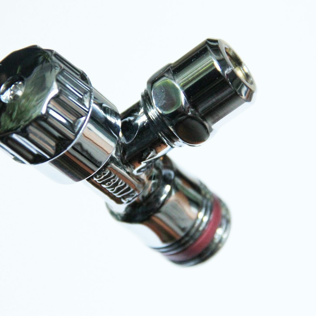 Close-up of a shiny, metallic valve connector with an adjustable knob.